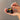 Hand holding open jar of Inlight Night Balm with spoon showing yellow balm
