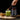 Spoon decanting matcha into a glass with the jar of Kiki Health Ceremonial Grade Organic Matcha Powder beside it