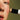 Model holding Madara Mineral SPF50 Stick up to her face to apply on green background