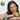 Model leaning on a table holding green apples with a bottle of Madara Exosomes Longevity Radiance Peptide Serum