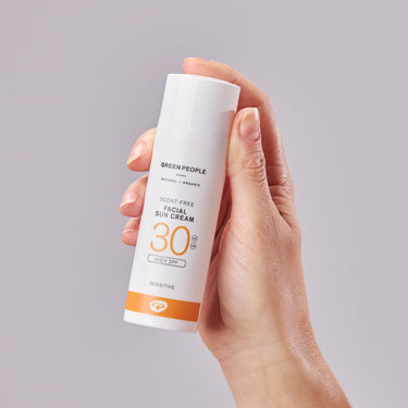 Model holding Green People Scent Free Facial Sun Cream SPF30 - Invisible with product benefits in text