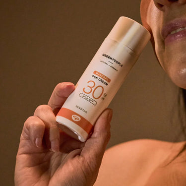 Model holding Green People Scent Free Facial Mineral Suncream SPF30 - Organic to face