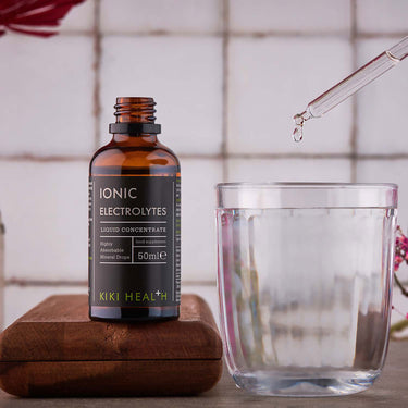 Kiki Health Ionic Electrolytes Mineral Concentrate being decanted into a glass of water