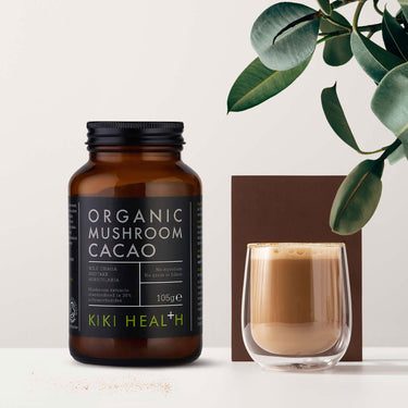Glass of cacao drink with the jar of Kiki Health Organic Mushroom Cacao Drink beside it