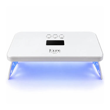 A white Kure LED lap desk lamp with a rectangular top, three control buttons, and a digital display, shown illuminated with blue light underneath on a white background.