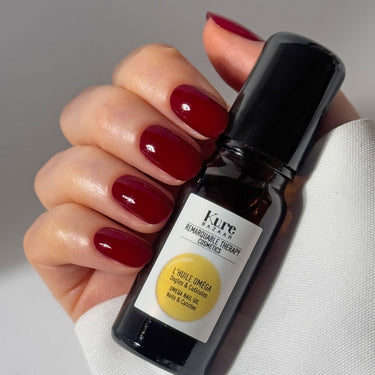Model holding Kure Bazaar Omega Nail & Cuticle Oil
