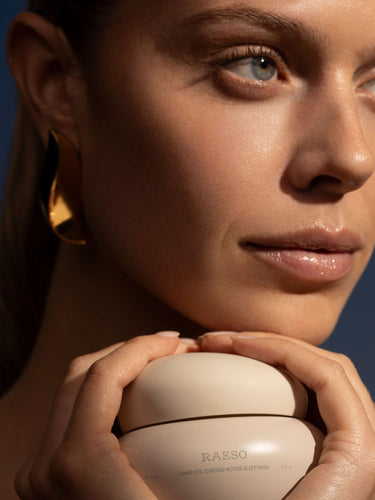 Model holding a jar of Raeso Lunar Veil Chrono-Active Sleep Treatment up to her face